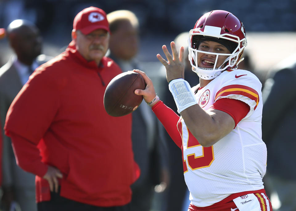 Kansas City Chiefs coach Andy Reid, left, watches quarterback Patrick Mahomes (15) warm up. (AP)