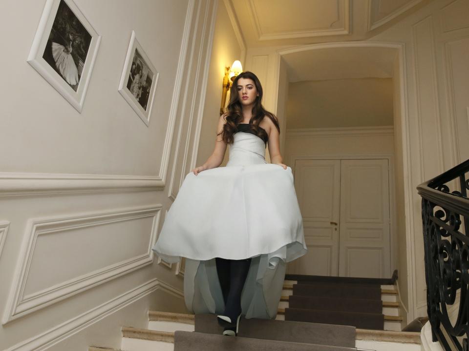 Kyra Kennedy goes down the stairs as she tries her new dress at Dior in Paris on November 27, 2013, ahead of the Debutantes Ball.