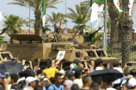 The crowd cheers soldiers in a tank during a military parade to mark the 60th anniversary of Algeria's independence, Tuesday, July 5, 2022 in Algiers. Algeria is celebrating 60 years of independence from France with nationwide ceremonies, a pardon of 14,000 prisoners and its first military parade in years. (AP Photo/Anis Belghoul)