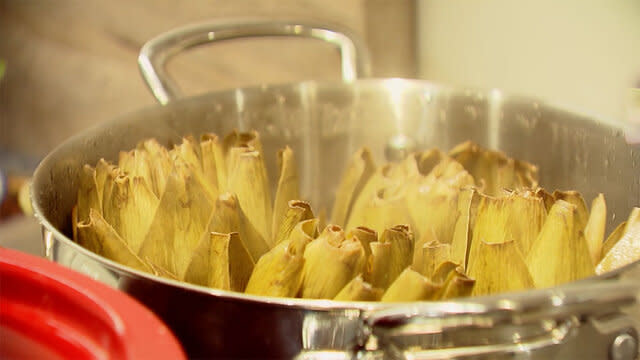 Artichokes cooking in a pot on the stove.