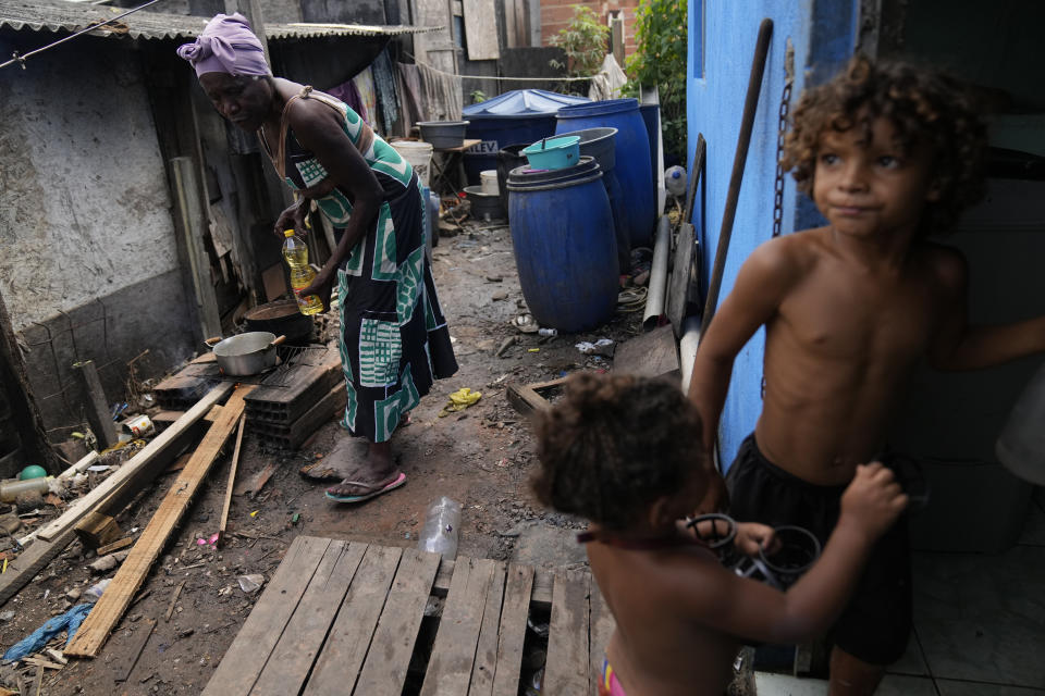 Lady Laurentino, 74, cooks in a wood fire near her home in the Jardim Gramacho favela of Rio de Janeiro, Brazil, Monday, Oct. 4, 2021. With the surge in cooking gas prices, Laurentino says she is cooking with wood because she doesn't have money to buy another cooking gas cylinder. (AP Photo/Silvia Izquierdo)