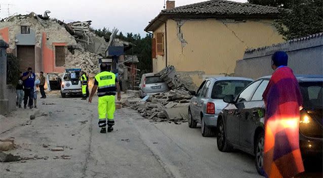 People stand along a road following a quake in Amatrice. Photo: Reuters/Emiliano Grillotti