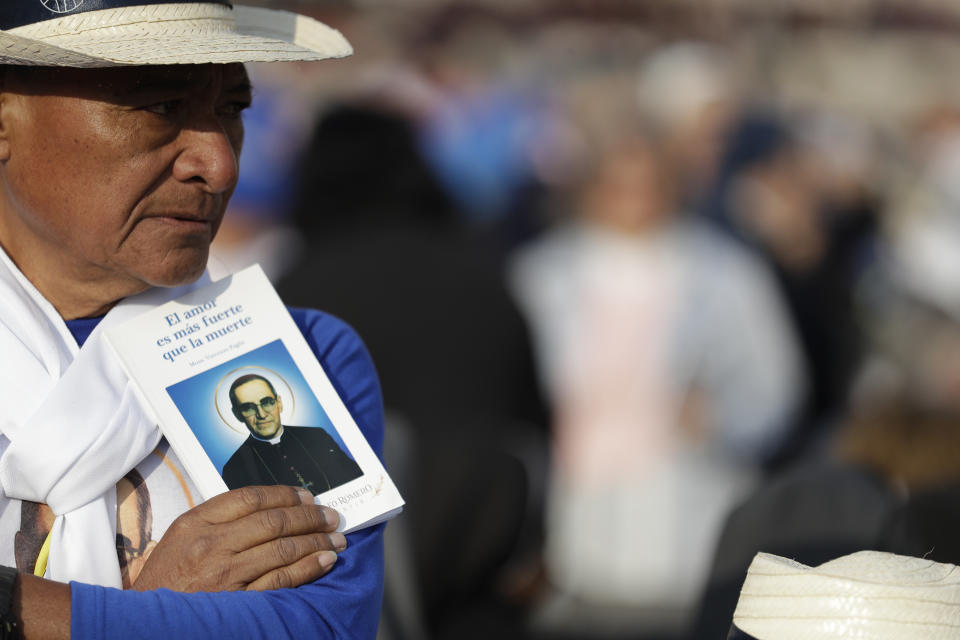 A man holds a picture of martyred Salvadoran Archbishop Oscar Romero prior to a canonization ceremony in St. Peter's Square at the Vatican, Sunday, Oct. 14, 2018. Pope Francis canonizes two of the most important and contested figures of the 20th-century Catholic Church, declaring Pope Paul VI and the martyred Salvadoran Archbishop Oscar Romero as models of saintliness for the faithful today. (AP Photo/Andrew Medichini)