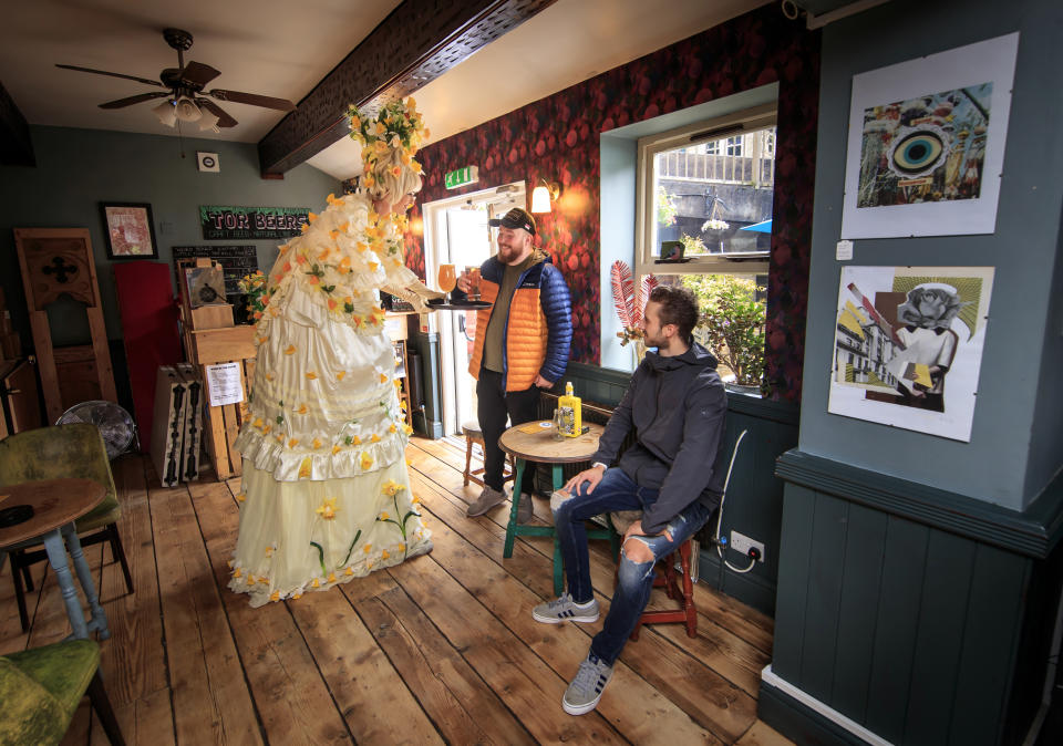 A street artist serves drinks to customers at the Golden Lion pub in Todmorden, West Yorkshire