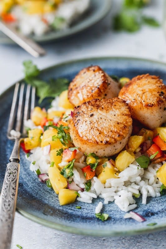 <p>Fork in the Kitchen</p><p>Seared scallops pair perfectly with creamy coconut rice and sweet pineapple salsa for the perfect summer dinner!</p><p><strong>Get the recipe: <a href="https://www.forkinthekitchen.com/seared-scallops-with-coconut-rice-pineapple-salsa/" rel="nofollow noopener" target="_blank" data-ylk="slk:Seared Scallops with Coconut Rice Pineapple Salsa;elm:context_link;itc:0;sec:content-canvas" class="link rapid-noclick-resp">Seared Scallops with Coconut Rice Pineapple Salsa</a></strong></p>