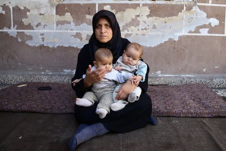 Six-month-old twins Safa and Marwa, who suffer from malnutrition, are held by their mother in the Hazzeh area, in the eastern Damascus suburb of Ghouta, Syria, October 25, 2017. REUTERS/Bassam Khabieh