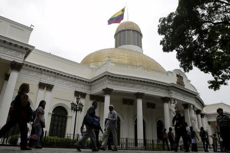 People walk past the National Assembly building during a parliamentary session in Caracas, April 5, 2016. REUTERS/Marco Bello