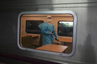 A health worker with protective gear walks inside a train as the train prepares to carry a group of COVID-19 patients to their hometowns, at Rangsit train station in Pathum Thani Province, Thailand, Tuesday, July 27, 2021. Thai authorities began transporting some people who have tested positive with the coronavirus from Bangkok to their hometowns on Tuesday for isolation and treatment, to alleviate the burden on the capital’s overwhelmed medical system. (AP Photo/Sakchai Lalit)