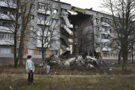 FILE - A woman passes by an apartment building damaged following by Russian shelling in Bakhmut, the site of the heaviest battles with the Russian troops, in the Donetsk region, Ukraine, Sunday, Dec. 11, 2022. (AP Photo/Andriy Andriyenko, File)