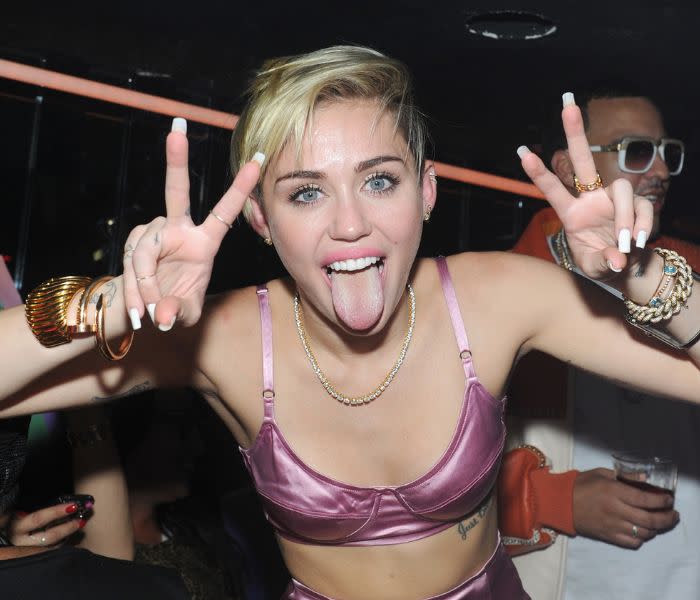 Miley Cyrus saca la lengua y hace el gesto de la victoria con las dos manos