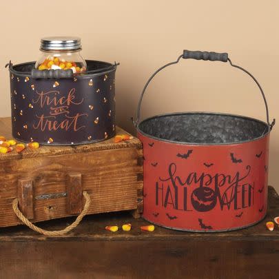 A pair of retro trick-or-treat buckets made of metal, so you can use these heirloom pieces as decor year after year