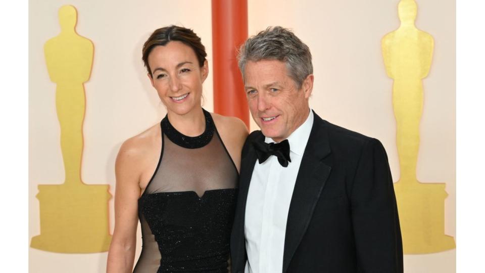 Anna Eberstein in a black dress and Hugh Grant in a black tuxedo