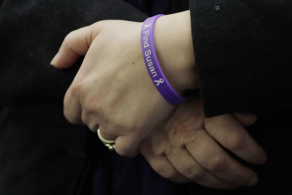 Denise Ernest, the sister of missing Utah woman Susan Cox Powell, wears a bracelet that reads "Find Susan," Tuesday, Feb. 18, 2020, during a break in a session of Pierce County Superior Court in Tacoma, Wash., on the first day of a civil lawsuit over the murder of the Susan's two young sons Charlie and Braden, who were attacked and killed by their father Josh Powell in 2012 while he was under suspicion for Susan Powell's disappearance. The parents of Susan Cox Powell allege that negligence by the Washington state Department of Social and Health Services was a contributing factor that led to the deaths of their grandsons. (AP Photo/Ted S. Warren)