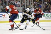 Boston Bruins left wing Jake DeBrusk (74) takes the puck down the ice against Florida Panthers defensemen MacKenzie Weegar (52) and Aaron Ekblad (5) during the first period of an NHL hockey game, Thursday, March 5, 2020, in Sunrise, Fla. (AP Photo/Wilfredo Lee)