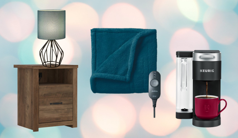 Nightstand with lamp, heated blanket, and Keurig coffee machine shown. 