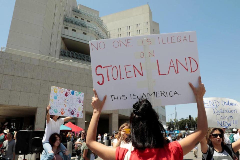 Demonstrators protest in front of the Metropolitan Detention Centre, Federal Bureau of Prisons, during a national day of action called “Keep Families Together” against the Trump administration’s ‘Zero Tolerance’ policy in Los Angeles on 30 June (Reuters)