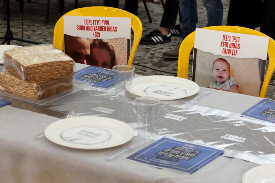Posters of Shiri, Yarden and Kfir Bibas, kidnapped and held hostage by the Palestinian militant group Hamas following the October 7 attack, are placed on a table in a communal dining hall in the Israeli Kibbutz Nir Oz during a passover ceremony and to call for the immediate release of the remaining hostages on April 11, 2024, amid continuing battles between Israel and Hamas. (Photo by JACK GUEZ / AFP) (Photo by JACK GUEZ/AFP via Getty Images)