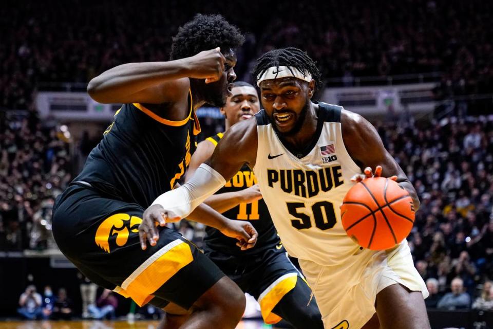 Purdue forward Trevion Williams (50) drives on Iowa forward Josh Ogundele (23) during the second half of an NCAA college basketball game in West Lafayette, Ind., Friday, Dec. 3, 2021.