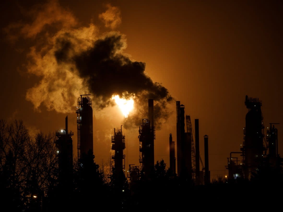 A flare stack lights the sky from the Imperial Oil refinery in Edmonton. Alberta announced $131 million investment in seven projects that are expected to cut about 2.9 million tonnes of emissions by 2030.  (Jason Franson/The Canadian Press - image credit)