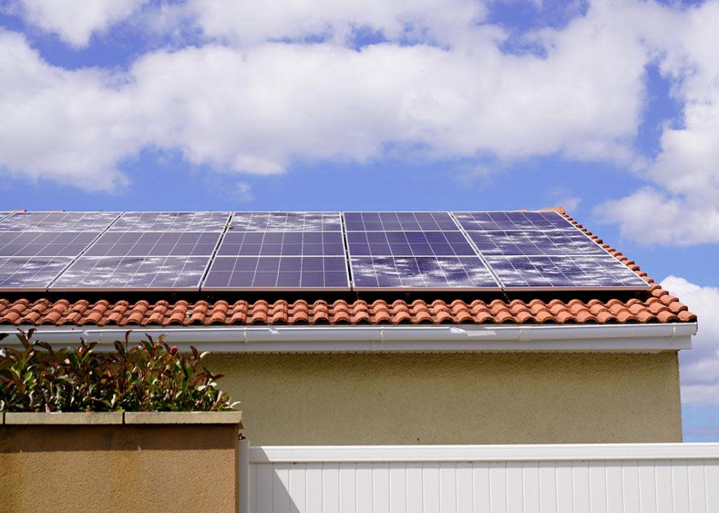 Solar panels on spanish tile roof with white spots of broken glass damaged from hailstorm. 