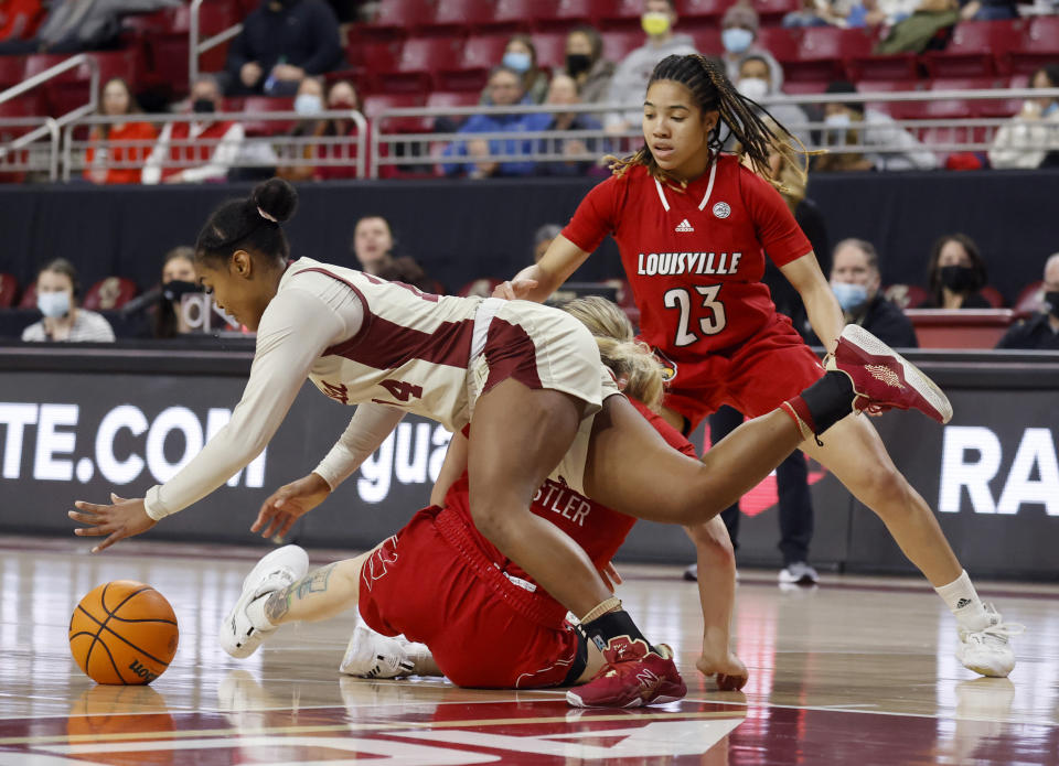 Boston College guard Marnelle Garraud (14) dives for a loose ball ahed of Louisville forward Emily Engstler and guard Chelsie Hall (23) during the first half of an NCAA college basketball game, Sunday, Jan. 16, 2022, in Boston. (AP Photo/Mary Schwalm)