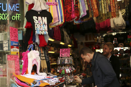 FILE PHOTO: Shoppers look over items at a souvenir store in San Francisco, California May 13, 2013. REUTERS/Robert Galbraith