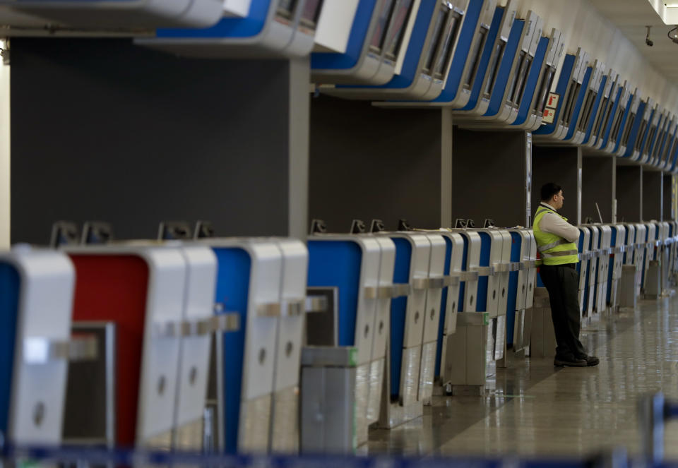 Un guardia se apoya en un mostrador de facturación en el aeropuerto donde se cancelaron cientos de vuelos debido a una huelga nacional en Buenos Aires, Argentina, el martes 25 de septiembre de 2018. (AP Foto / Natacha Pisarenko)