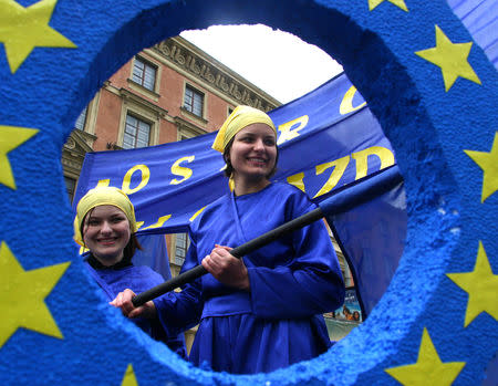 Two Polish girls pose in front of a huge symbolic key signifying Poland's entry into the European Union during Europe day celebrations in Warsaw May 8, 2004. REUTERS/Katarina Stoltz/Files