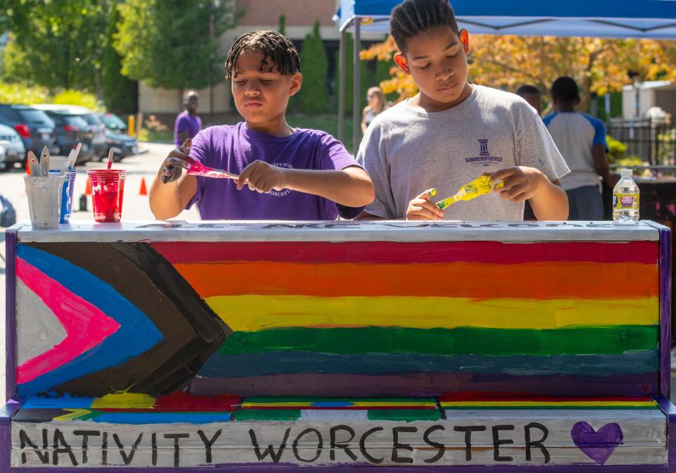 Nativity School students Jalen Morales, left, and Brandon Diaz splatter paint onto a piano outside the First Baptist Church Friday.