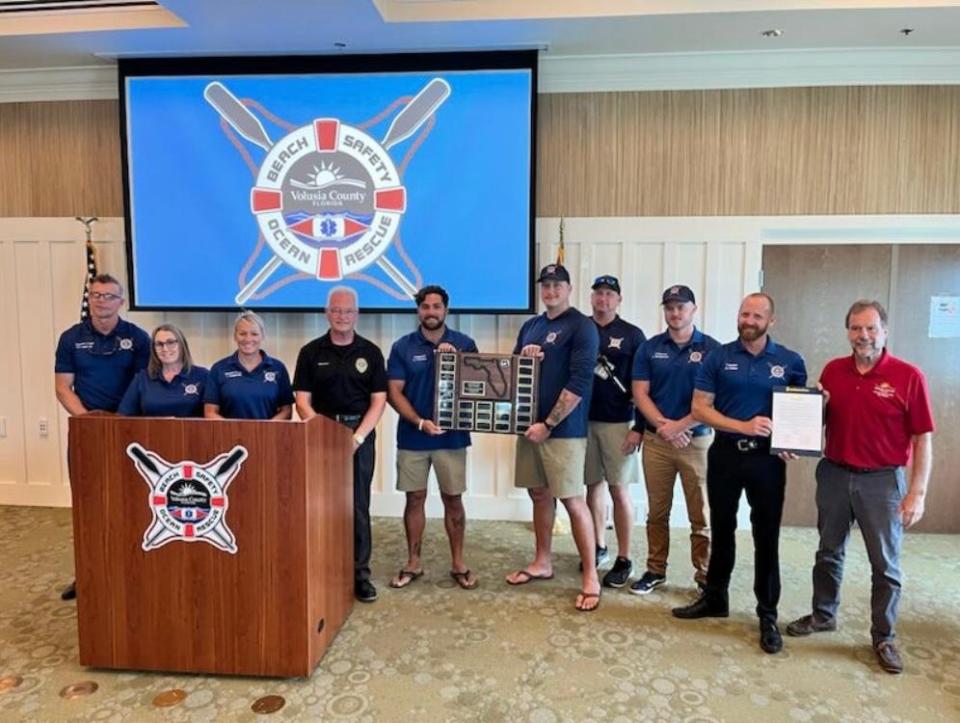 Volusia County Beach Safety Officials and County Council Chairman Jeff Brower pose with the Council's National Beach Safety Week proclamation and Beach Safety's 2023 Beach Patrol of the Year award from the Florida Beach Patrol Chiefs Association.