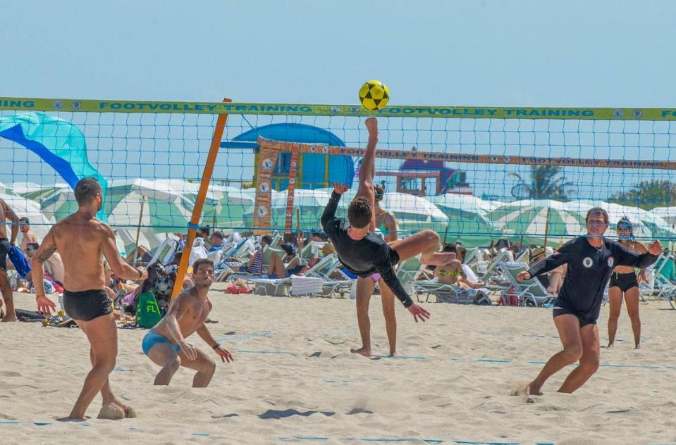 Footvolley players goes after the ball during a match in the sand, during spring break in Miami Beach, on Saturday March 16, 2024.