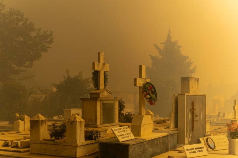 A cemetery in Penteli, a municipality in the northern Athens region, is seen shrouded in thick smoke, as wild fires are raging over 200 square kilometers near Athens. EU member states are sending aid to Greece to help emergency services in battling the country's biggest wildfire of the year on Monday, with multiple flash points burning across some 200 square kilometres of woodland north-east of the capital Athens. Socrates Baltagiannis/dpa