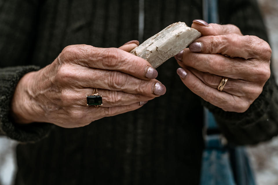 Mary Freeman holds a spodumene crystal, which contains lithium, found in the test pit she and her husband Gary own in Newry, Maine, on June 6.<span class="copyright">Garrick Hoffman—The Maine Monitor</span>