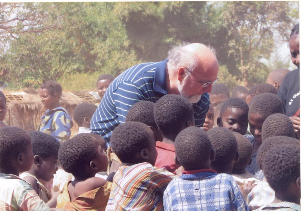 Dr. Robert Redfield greets a group of children in Africa during his time with the Institute of Human Virology at the University of Maryland School of Medicine.