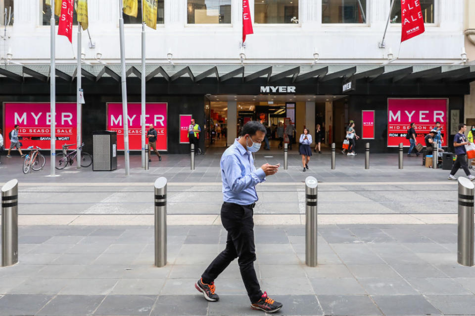 A man wearing a face mask walks past large Australian retailer Myer Bourke Street  in Melbourne, Australia. 