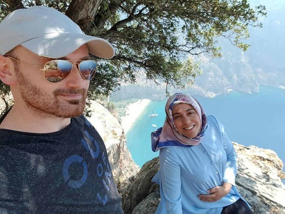 Hakan and Semra Aysal. He wears a cap and sunglasses as she holds her growing belly.