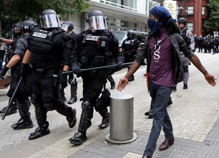 A counter-protester flanks the law enforcement after a Proud Boys rally in Portland, Oregon