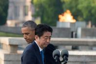 A flame flickered behind Japanese Prime Minister Shinzo Abe (front R) and US President Barack Obama (L) as they spoke in turn at the Hiroshima Peace Memorial Park on May 27, 2016 in a ceremony loaded with symbolism