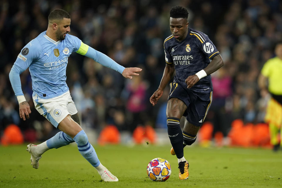 Manchester City's Kyle Walker fights for the ball with Real Madrid's Vinicius Junior during the Champions League quarterfinal second leg soccer match between Manchester City and Real Madrid at the Etihad Stadium in Manchester, England, Wednesday, April 17, 2024. (AP Photo/Dave Thompson)