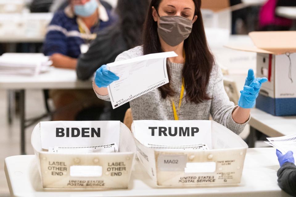 An election worker places a ballot in a counted bin during a hand recount of Presidential votes on Sunday, Nov. 15, 2020 in Marietta, Ga.