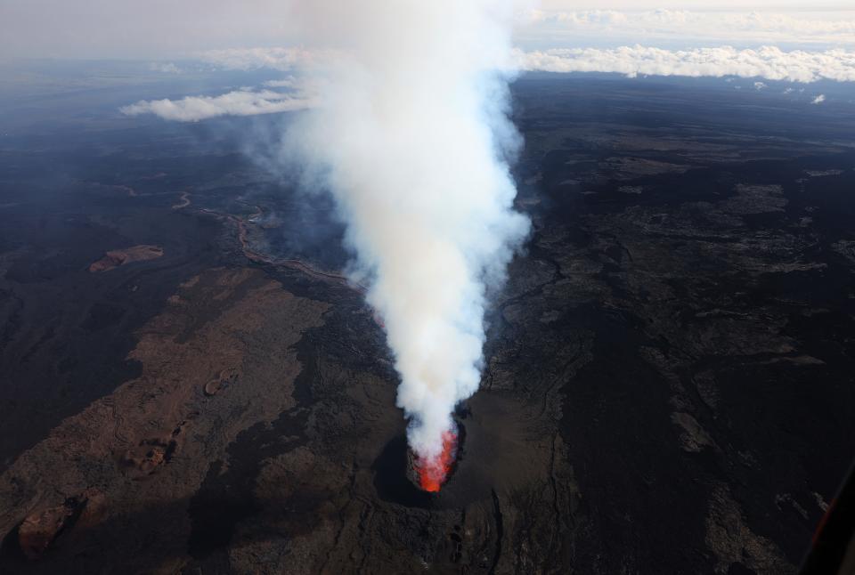 In an aerial view, lava shoots up from a fissure of Mauna Loa Volcano as it erupts on Monday in Hilo, Hawaii. For the first time in nearly 40 years, the Mauna Loa volcano, the largest active volcano in the world, has erupted.