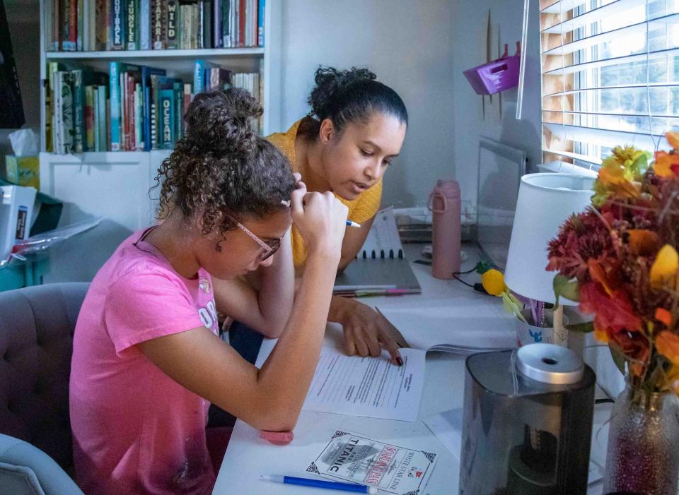 Charisma Hernandez (l) helps her daughter Sakura, 13, with a homework assignment. Hernandez has home schooled Sakura and her twin sister Akira since the pair were in kindergarten.