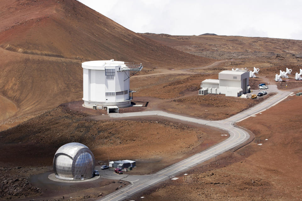 FILE - In this Aug. 31, 2015, file photo, from bottom left, the Caltech Submillimeter Observatory, the James Clerk Maxwell Telescope and the Submillimeter Array, far right, are shown on Hawaii's Mauna Kea near Hilo, Hawaii. Astronomers across 11 observatories on Hawaii’s tallest mountain have cancelled more than 2,000 hours of telescope viewing over the past four weeks because a protest blocked a road to the summit. Mauna Kea is one of the world’s premier sites for studying the skies. (AP Photo/Caleb Jones, File)