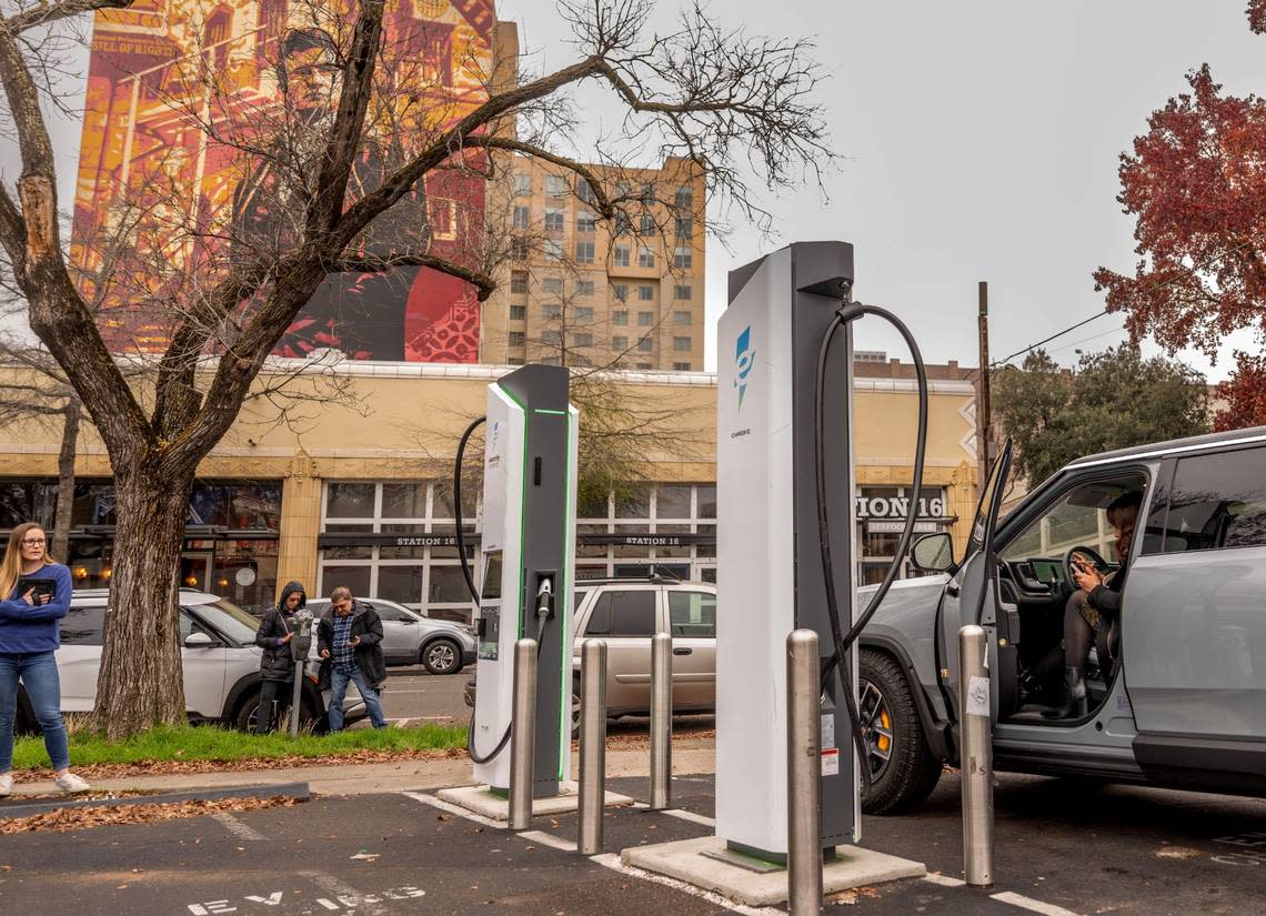 Sacramento resident Angie Manetti looks for information on how to charge her car on earlier this month in downtown Sacramento at an Electrify America station.