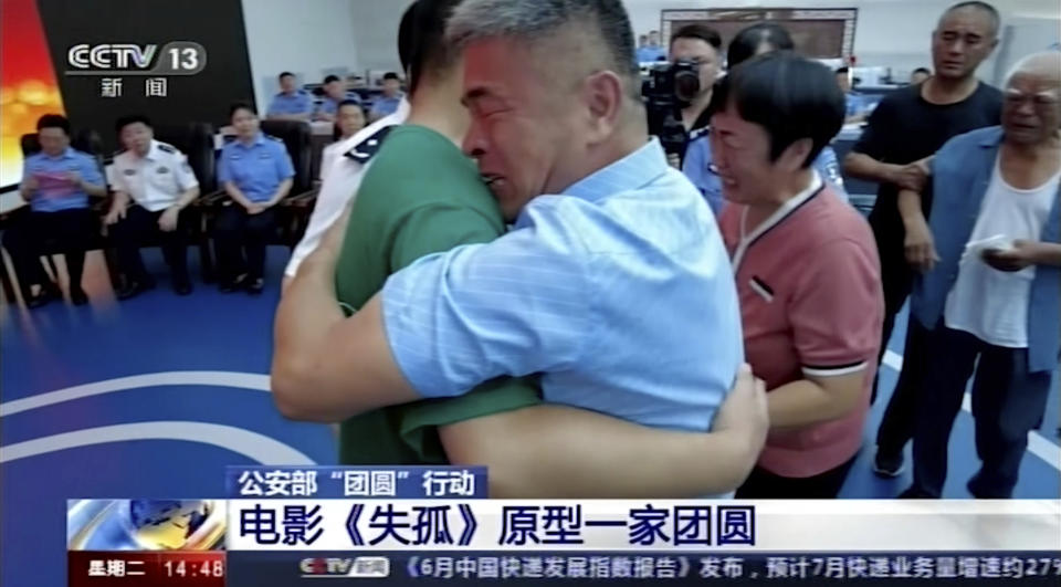 Guo Gangtang at right embraces his long lost son Guo Xinzhen. Source: AP