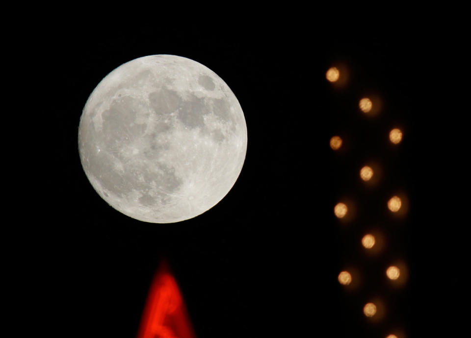 La luna se alza detrás de un letrero de neón en Sacramento, California, el domingo 13 de noviembre de 2016. (AP Photo / Rich Pedroncelli)