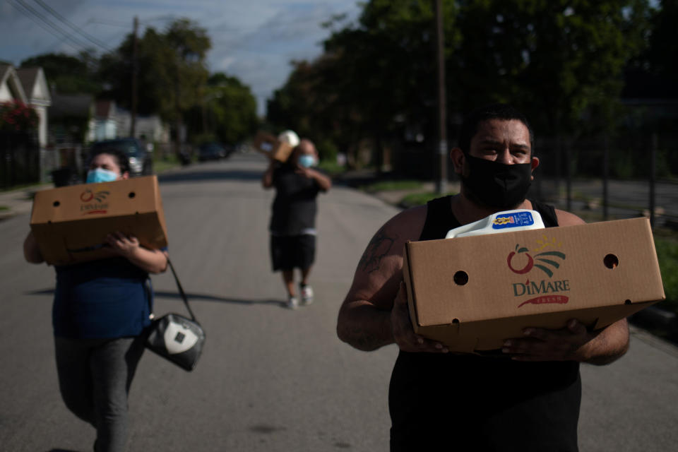 Jesus Martinez carries groceries distributed by the Wesley Community Center to residents affected by the economic fallout from the coronavirus disease (COVID-19) outbreak in Houston, Texas, U.S., July 31, 2020.   REUTERS/Adrees Latif