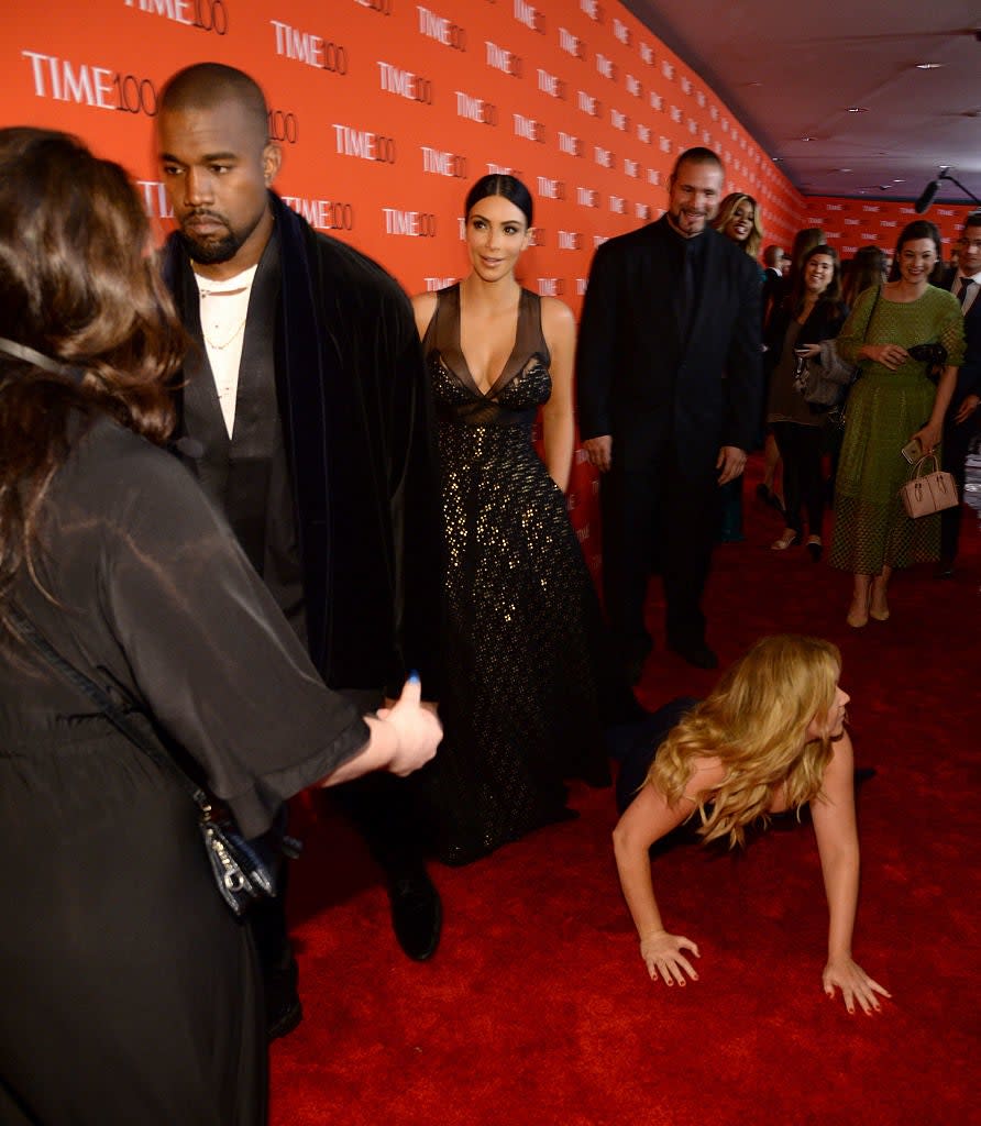 Kim Kardashian in a black dress with sequins and Kanye West in a black velvet suit on the TIME 100 red carpet, where Amy Schumer pretended to fall