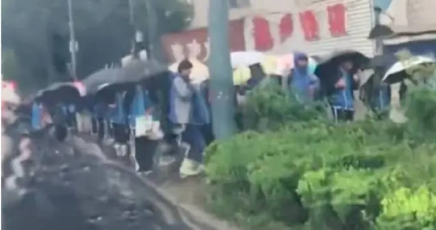 學生們在雨中等待校門開。（圖／翻攝自微博）