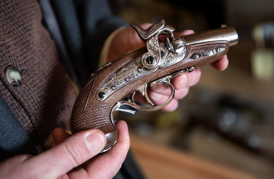 Columbia Booksellers and Variety Store owner Michael Sharps holds a non-firing replica Deringer flint-lock pistol at his store in Columbia, Calif., on Friday, Jan. 22, 2021. The Columbia State Historic Park shop was forced to close after its point-of-sale account was canceled by San Francisco tech service Square over replica guns.
